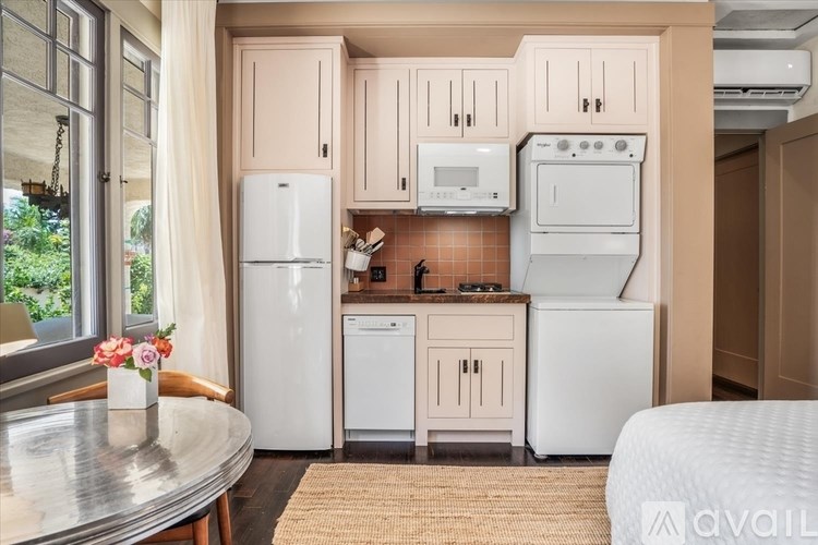 A kitchen with white appliances and wooden cabinets.