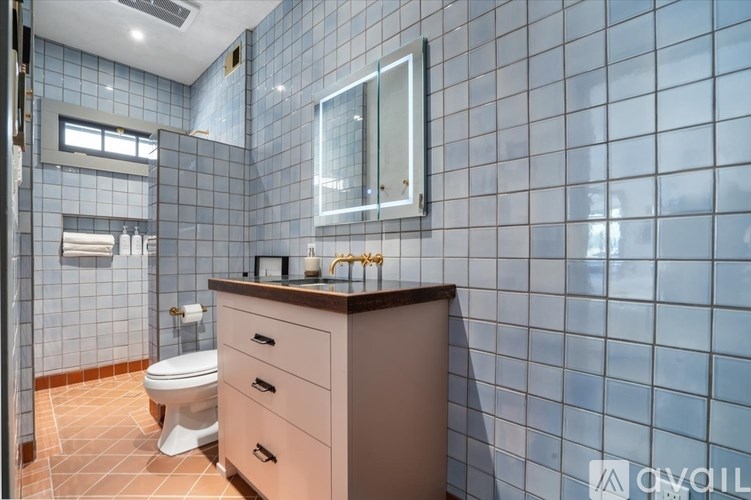 A bathroom with a toilet, sink, and mirror.