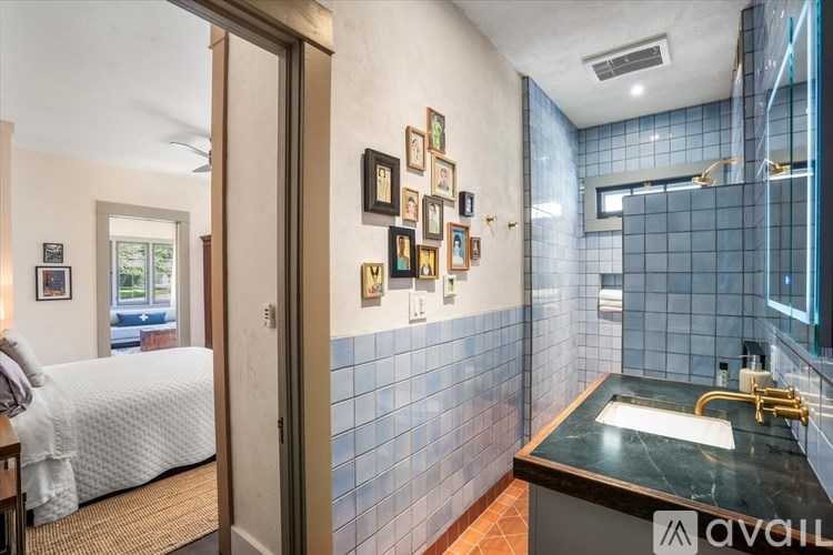 A bathroom with a sink and a bedroom in the same room.