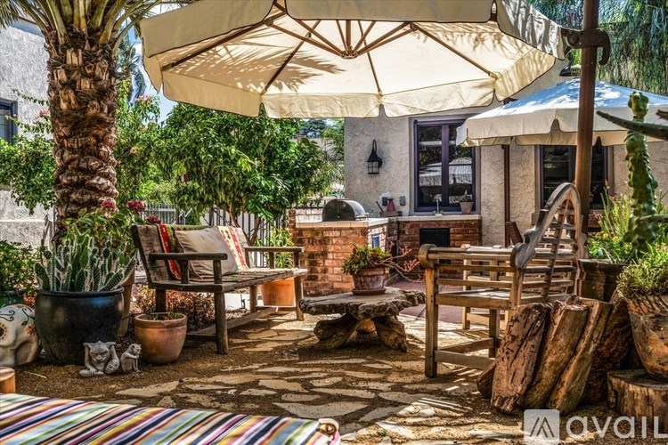 A house with a red tile roof and a black gate is for sale.