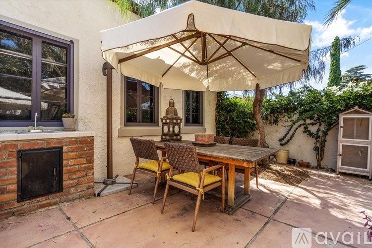 A patio with a table and chairs under an umbrella.