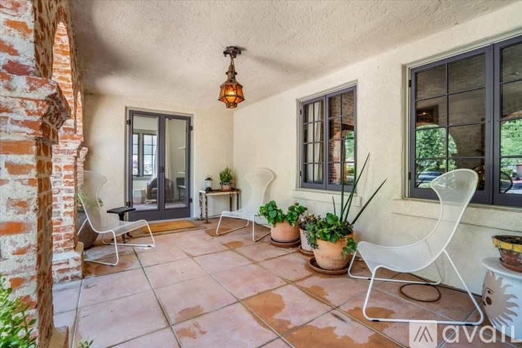 A patio with a brick column and a table with chairs.