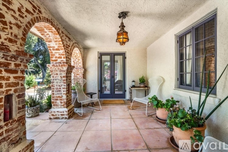 A patio with a chair and a table with a plant on it.