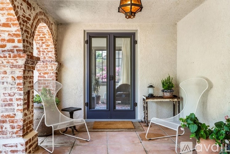 A patio with a table, chairs and a door.