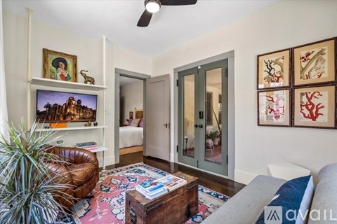 A living room with a brown leather chair and a rug with a pattern of red, blue, and white.