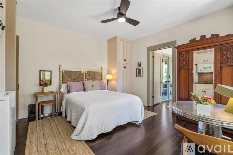 A bedroom with a large bed and a ceiling fan.