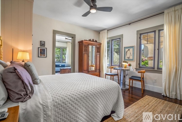 A bedroom with a large bed and a ceiling fan.