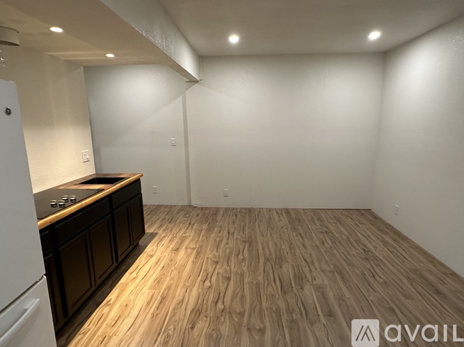 A kitchen with wooden flooring and white walls.