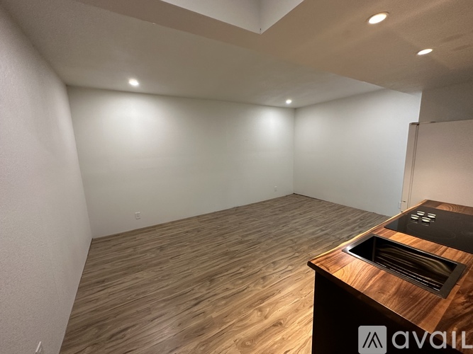 A room with wooden flooring and a counter with a sink.