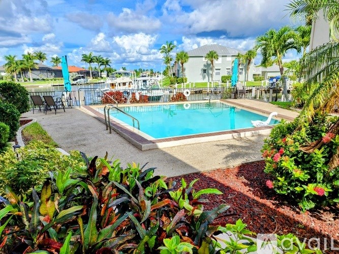 A pool surrounded by green plants and trees.