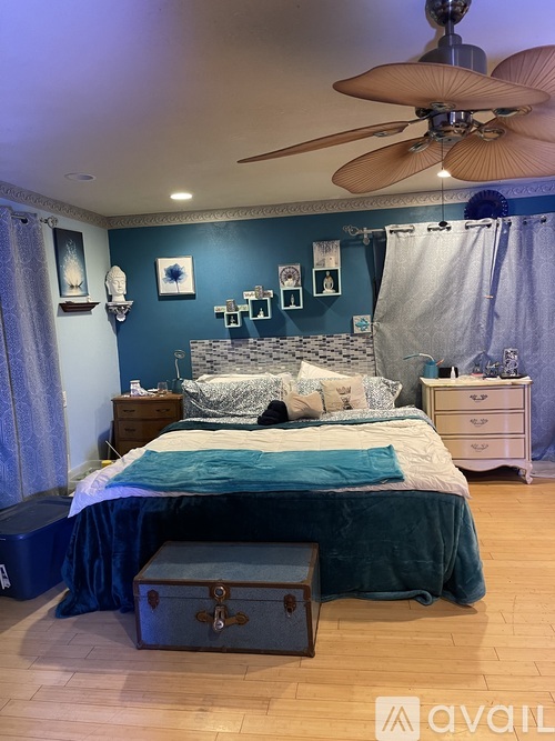 A bedroom with a bed, dresser, and trunk.