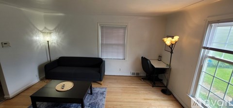 A living room with a black couch and a coffee table.