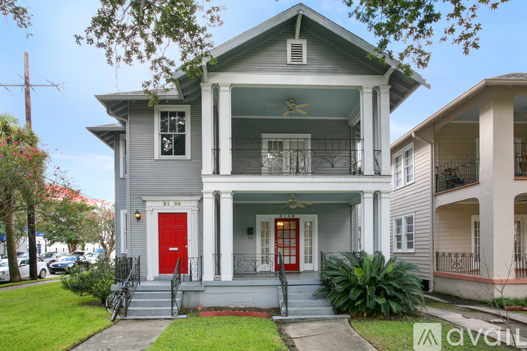 A two-story house with a red door and white trim.