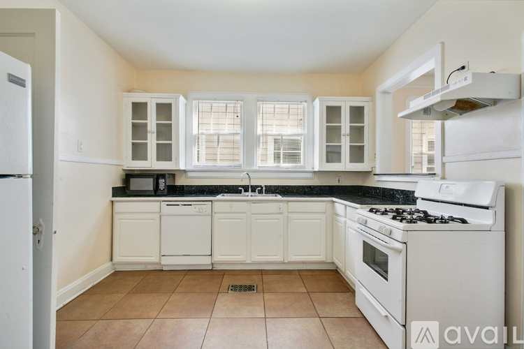 A kitchen with white appliances and cabinets.