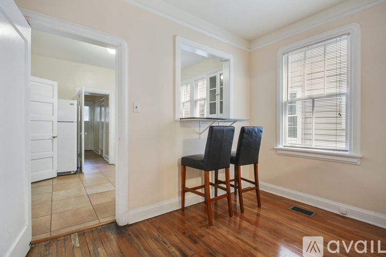 A room with a wooden floor, a chair, and a mirror.