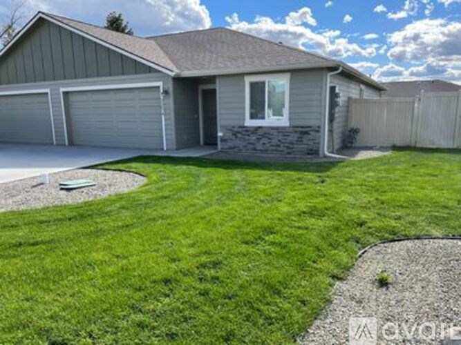 A house with a grey garage door and a white window.