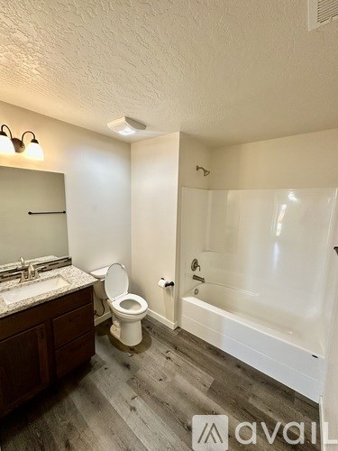 A bathroom with a toilet, sink, and bathtub.