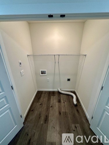 A room with a white wall and a wooden floor.