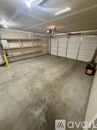A large, empty garage with a concrete floor and white walls.