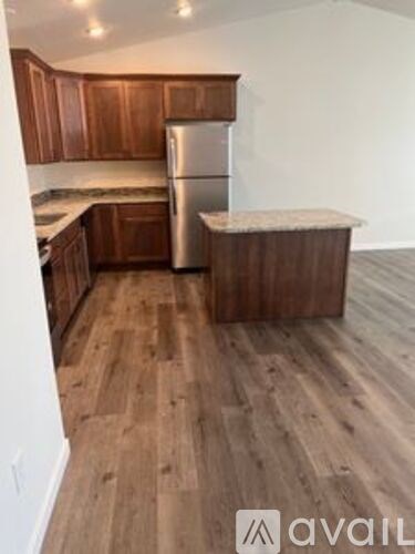 A kitchen with wooden cabinets and a refrigerator.