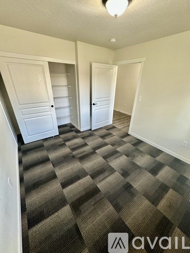 A backyard with a white fence and a house.
