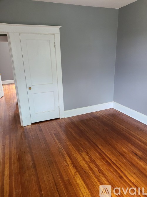 A room with a wooden floor and a white door.
