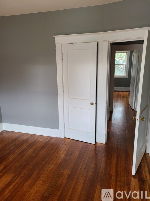 A room with a wooden floor and a white door.