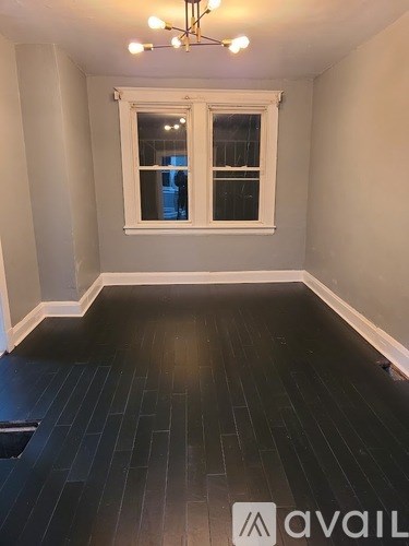 A room with a window and a chandelier.