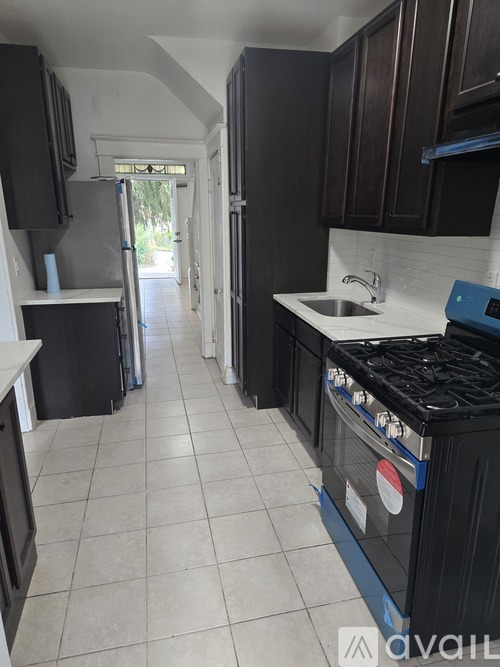 A kitchen with dark brown cabinets and a white countertop.
