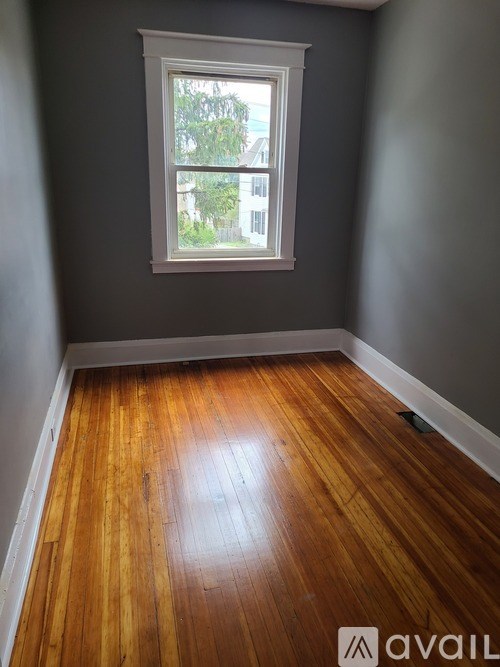 A room with wooden flooring and a window.