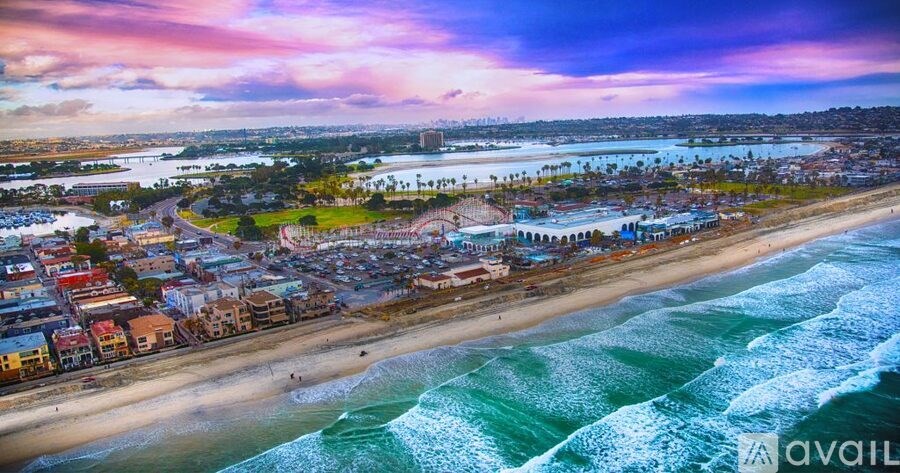 A beachfront city with a large body of water and waves crashing onto the shore.