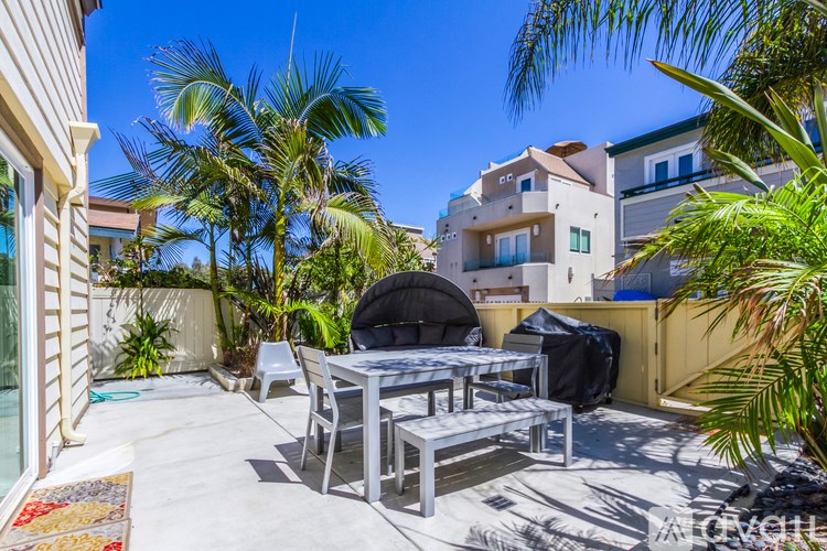 A patio with a table and chairs surrounded by palm trees.