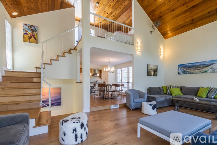 A living room with a grey couch and a white ottoman.