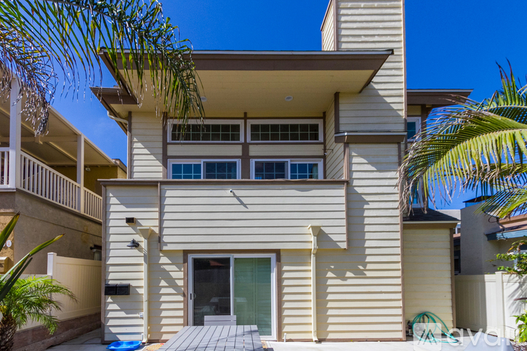 A two-story house with a balcony and a pool.