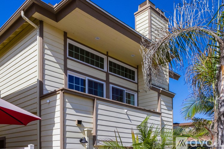 A house with a red umbrella in front of it.