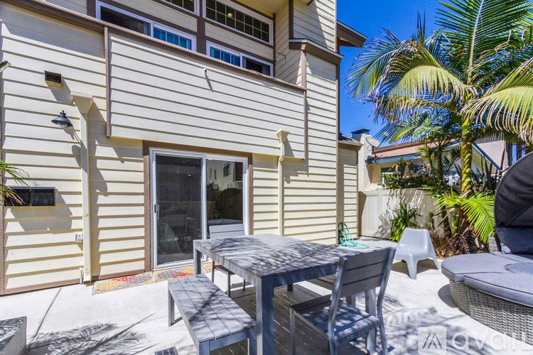 A patio with a table and chairs is set up outside a house.