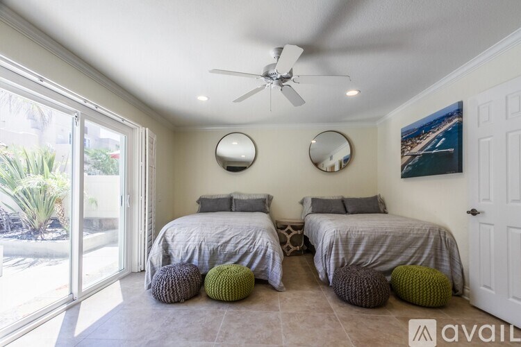 A bedroom with two beds and a ceiling fan.