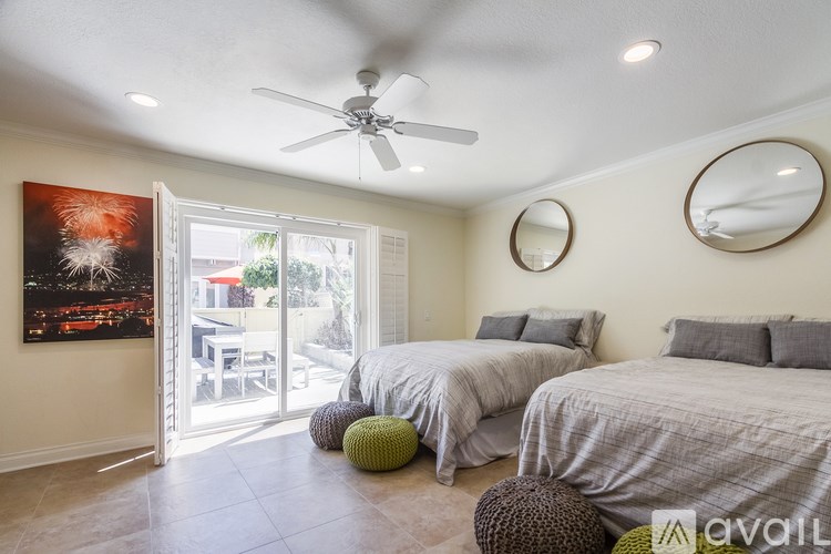 A bedroom with two beds and a ceiling fan.