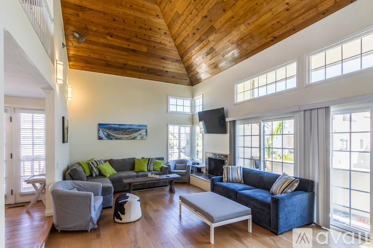 A living room with a wooden ceiling and a large sectional sofa.