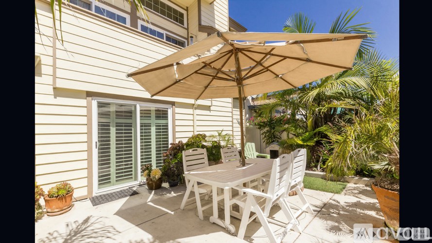A patio with a table and chairs under an umbrella.