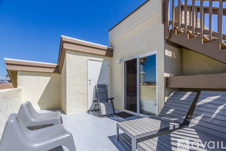 A modern house with a balcony and a white chair.