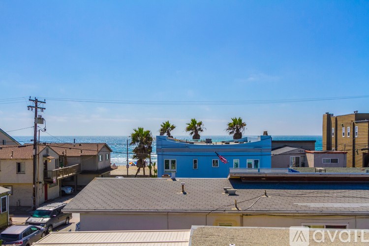 A blue building with a flag on it is in the middle of a street.