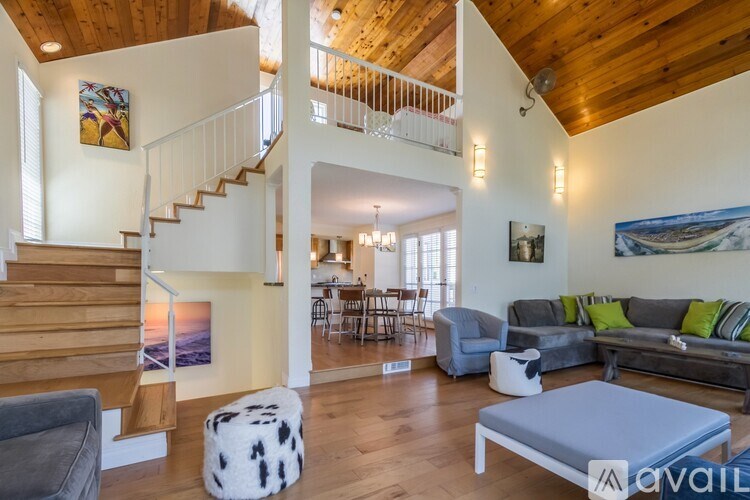 A living room with a grey couch and a white ottoman.