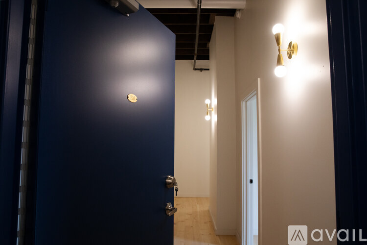 A dark blue door with a gold handle and a small round logo on the door.