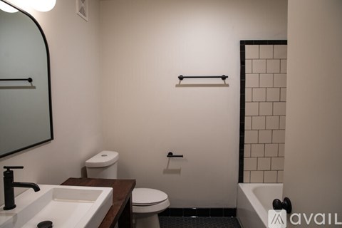 A bathroom with a toilet, sink, and a shower.