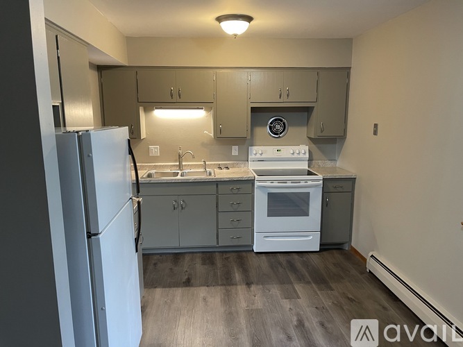 A kitchen with a white refrigerator, white stove, and white oven.