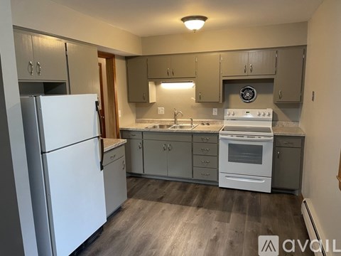 A kitchen with a white refrigerator and a white stove top oven.