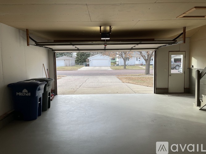 A spacious garage with a view of a residential area through the open door.