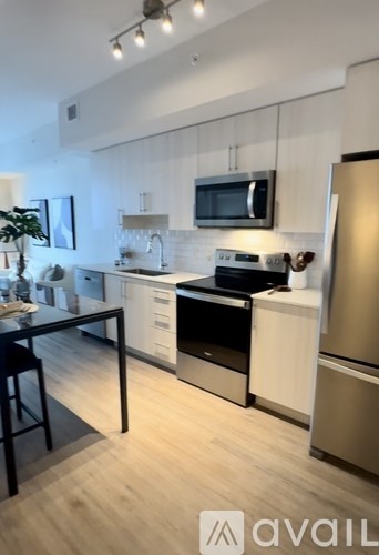 A kitchen with a black table and a refrigerator.