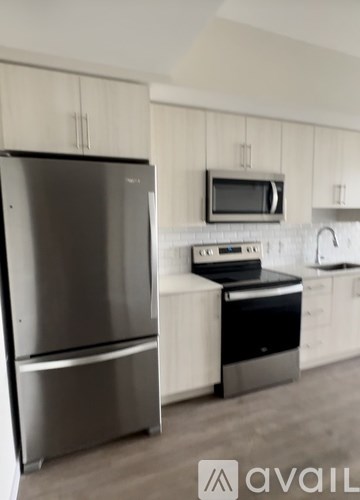 A modern kitchen with a stainless steel refrigerator and oven.